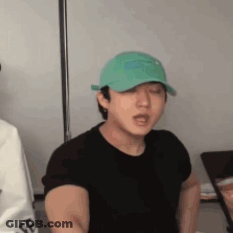 Man In Green Hat And Black Shirt With Eyes Closed GIF