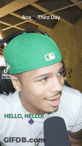 Man In Green Hat And Headphones Talking Into Microphone GIF
