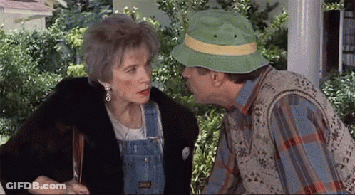 Man In Green Hat Kissing Woman On Cheek GIF