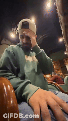 Man In Green Hoodie And White Hat Covering Face GIF