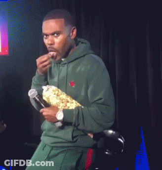 Man In Green Hoodie Holding Microphone And Popcorn GIF