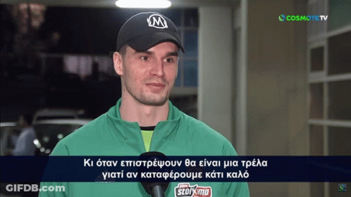 Man In Green Jacket And Black Cap Interviewed By Cosmote TV GIF