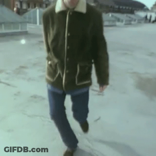 Man In Green Jacket And Blue Jeans On Rooftop GIF