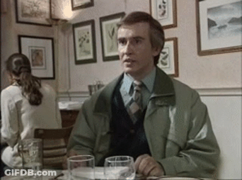 Man In Green Jacket And Tie At Table GIF