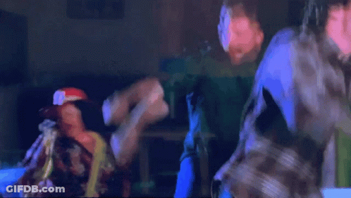 Man In Green Jacket And Yellow Tie Held By Man GIF