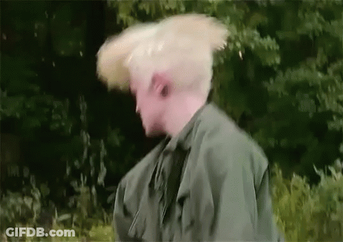 Man In Green Jacket Hair Blowing In Wind GIF
