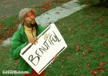 Man In Green Jacket Holding Beautiful Sign GIF