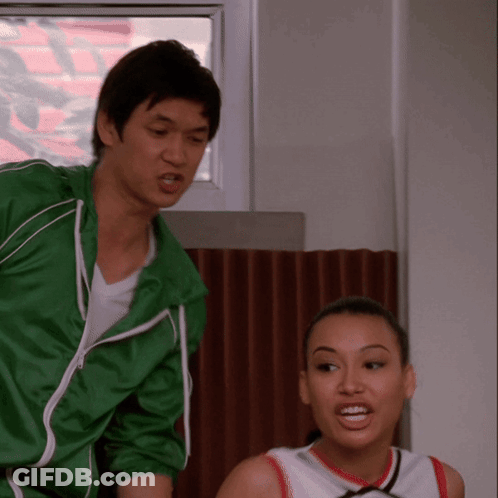 Man In Green Jacket Next To Cheerleader GIF