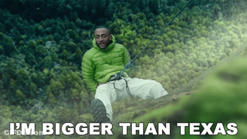 Man In Green Jacket On Cliff Saying I'm Bigger Than Texas GIF