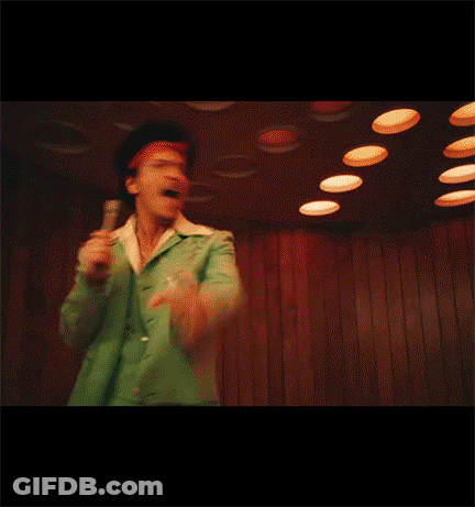 Man In Green Jacket Singing Into Microphone And Pointing GIF