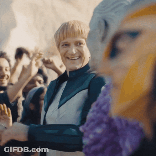 Man In Green Jacket Smiling In Crowd GIF