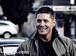Man In Green Jacket Smiling In Front Of Car GIF