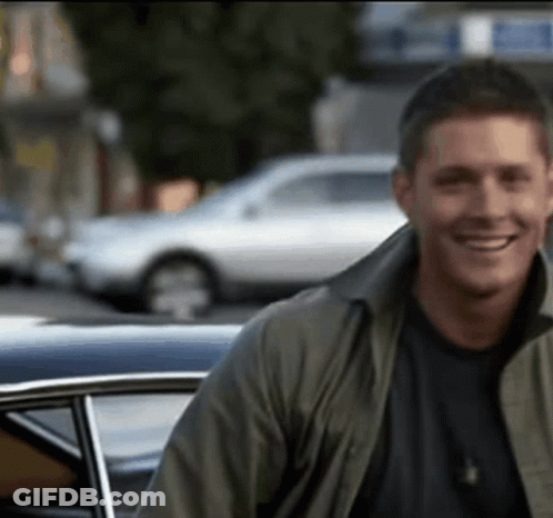 Man In Green Jacket Smiling Next To Car GIF
