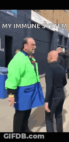 Man In Green Jacket Talking To Man In Blue Apron GIF