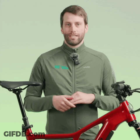 Man In Green Jacket With Alpina Beside Red Bike GIF