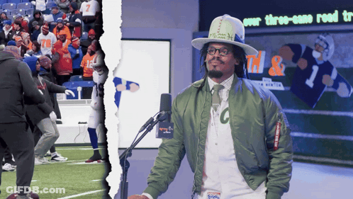 Man In Green Jacket With Letter C At Microphone GIF