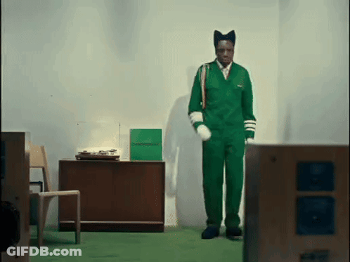 Man In Green Jumpsuit In Front Of Record Player GIF