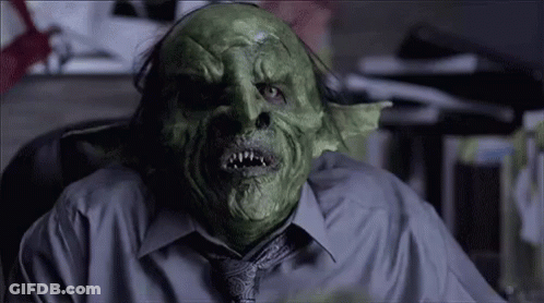 Man In Green Mask Sitting In Chair GIF