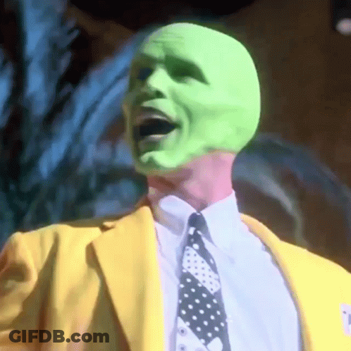 Man In Green Mask, Yellow Suit, And Tie GIF