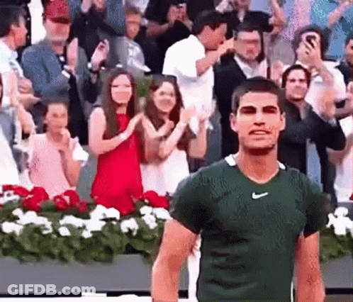 Man In Green Nike Shirt Walking In Front Of Crowd GIF