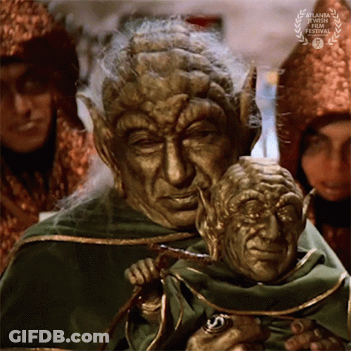 Man In Green Robe Holding Puppet GIF