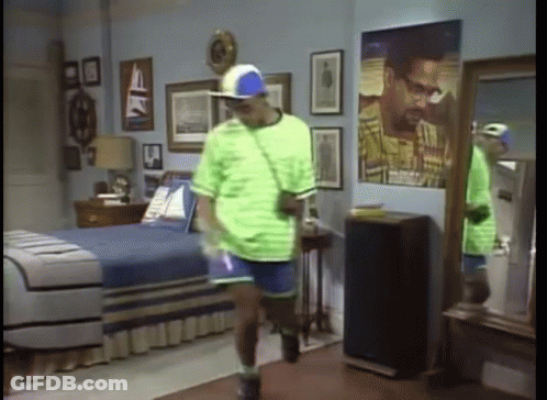 Man In Green Shirt And Blue Hat In Bedroom GIF