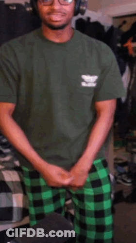 Man In Green Shirt And Plaid Pants At Microphone GIF