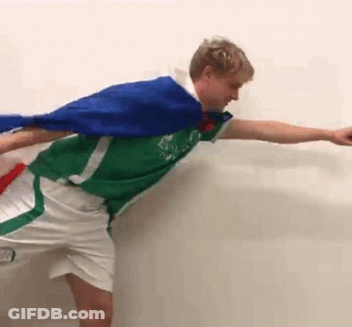 Man In Green Shirt And White Shorts Holding Blue Cape GIF