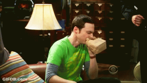 Man In Green Shirt Eating Food On Couch GIF