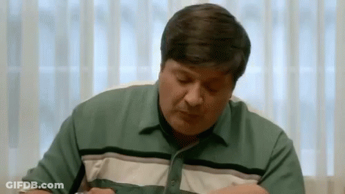 Man In Green Shirt Eating With Eyes Closed GIF