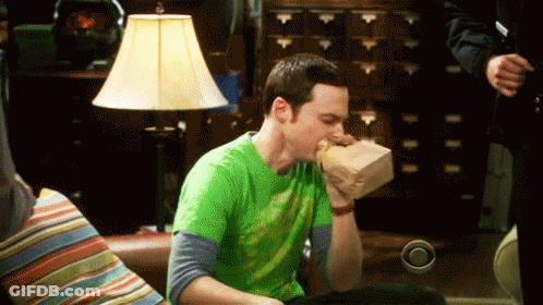 Man In Green Shirt Holding Bag In Mouth GIF