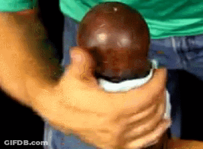 Man In Green Shirt Holding Large Brown Egg GIF