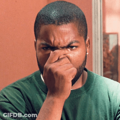 Man In Green Shirt Holding Nose GIF