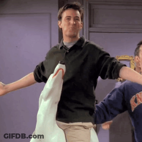 Man In Green Shirt Holding Stuffed Shark GIF