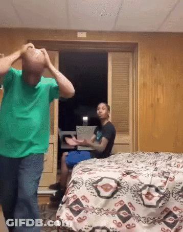 Man In Green Shirt In Front Of Bed GIF