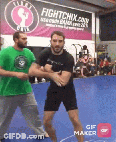 Man In Green Shirt In Front Of Fightchix.com Sign GIF