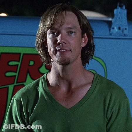 Man In Green Shirt In Front Of Scooby Doo Vehicle GIF
