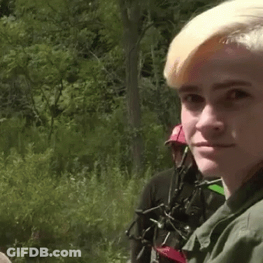 Man In Green Shirt Looking In Distance In Woods GIF