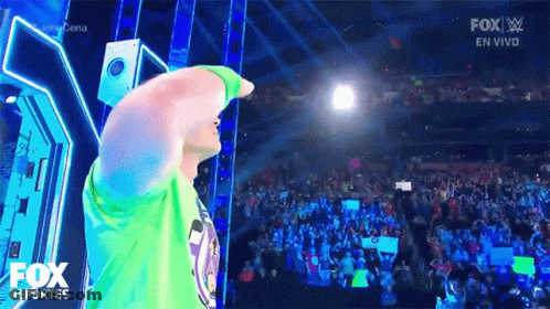 Man In Green Shirt On Stage With Fox Logo And Crowd GIF