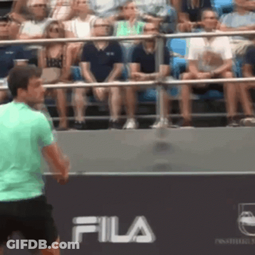 Man In Green Shirt Playing Tennis In Front Of Fila Banner GIF