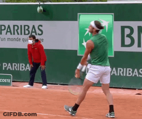 Man In Green Shirt Playing Tennis In Front Of Paribas Banner GIF