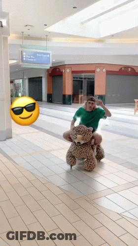 Man In Green Shirt Riding Teddy Bear GIF