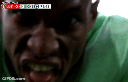 Man In Green Shirt Screaming In Front Of Premier League Scoreboard GIF