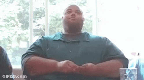 Man In Green Shirt Sitting With Folded Hands GIF