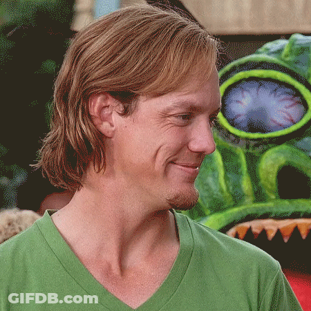 Man In Green Shirt Smiling In Front Of Monster GIF
