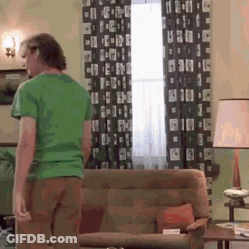Man In Green Shirt Standing In Living Room GIF