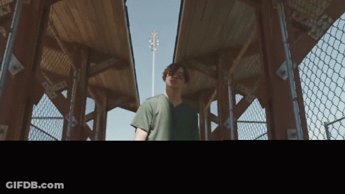 Man In Green Shirt Walks In Park GIF