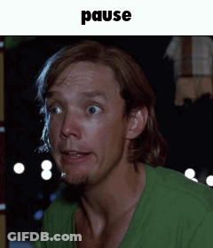 Man In Green Shirt With Pause Above GIF