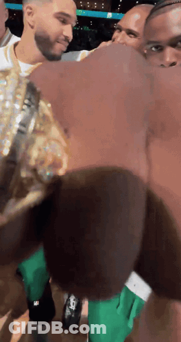 Man In Green Shorts Next To Man In Gold GIF