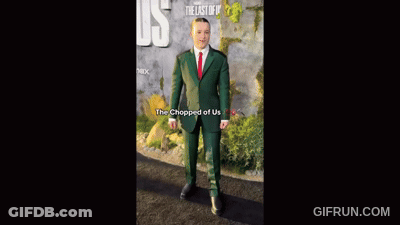 Man In Green Suit And Red Tie In Front Of The Last Of Us Sign GIF